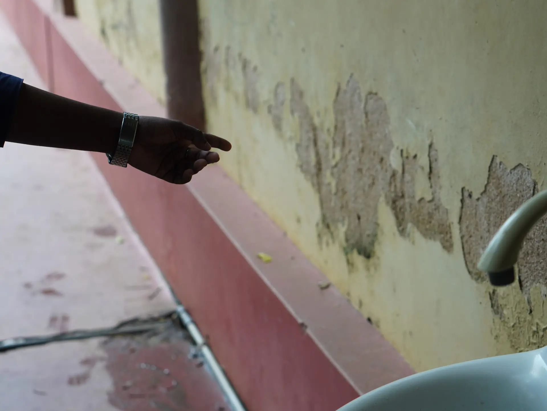 Paint falling off from the walls unmasking the damp concrete walls that are weakened, after the floods, creating an occupational hazard for the doctors working in the OPD, and for the patients as well.